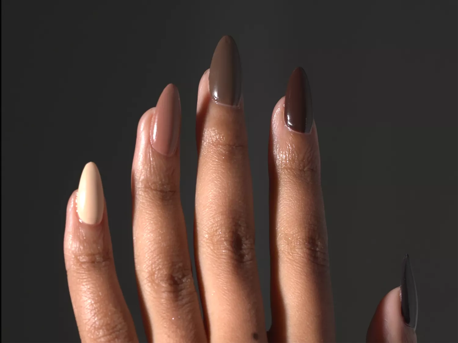 Assorted chocolate nails, slightly slanted, against a dark gray background