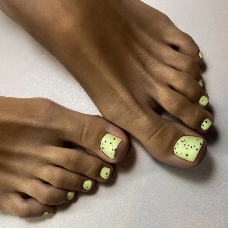 yellow polish black splatter toe nail trends 2023