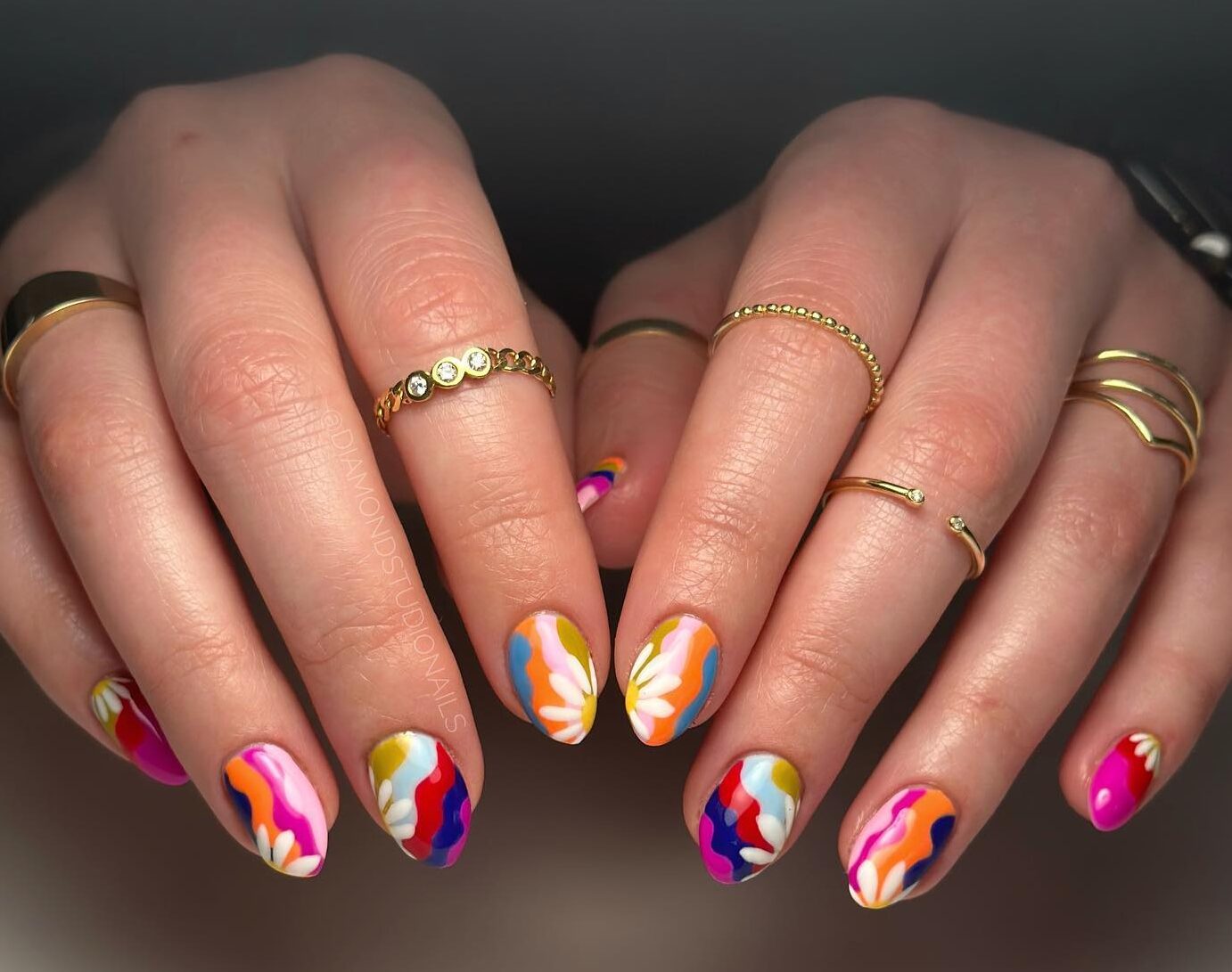 Colorful swirls with white flowers on short almond nails