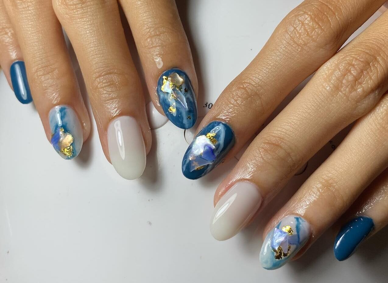 Blue and white nail polish with marble nail art and gold foil on short round nails