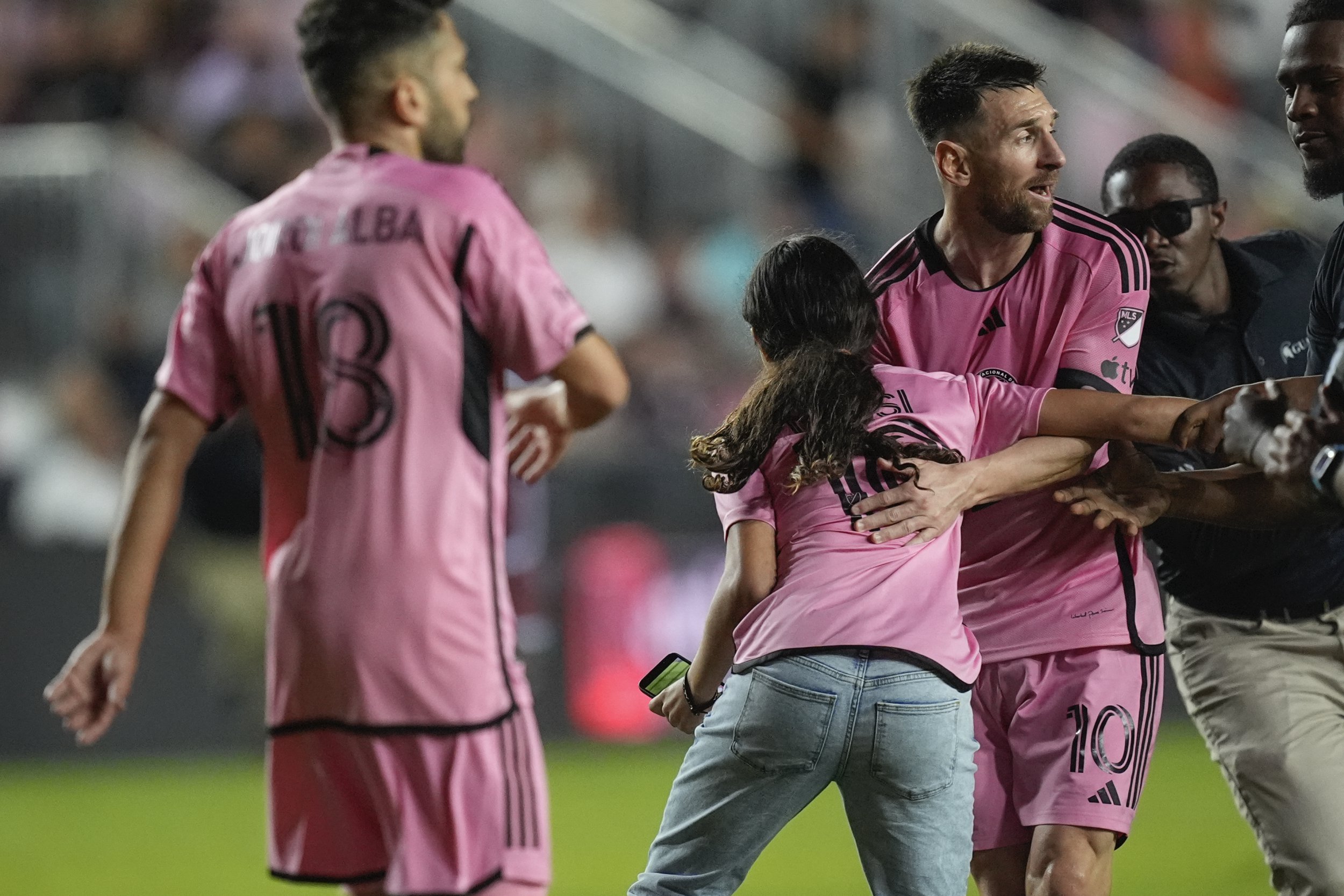 Lionel Messi was surprised by a fan running onto the field during the match