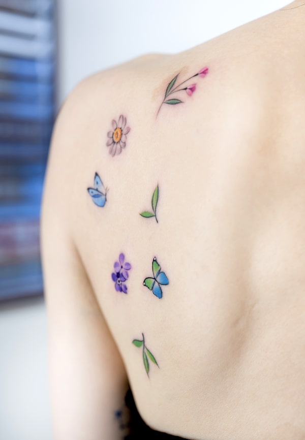 Cute little flowers and butterflies back tattoo by @foret_tattoo