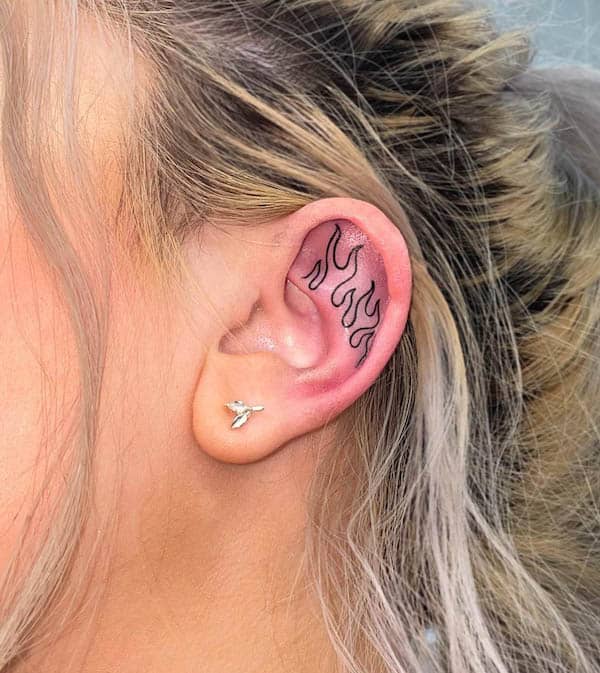 Small flames inner ear tattoo by @maxreeder_tattoo