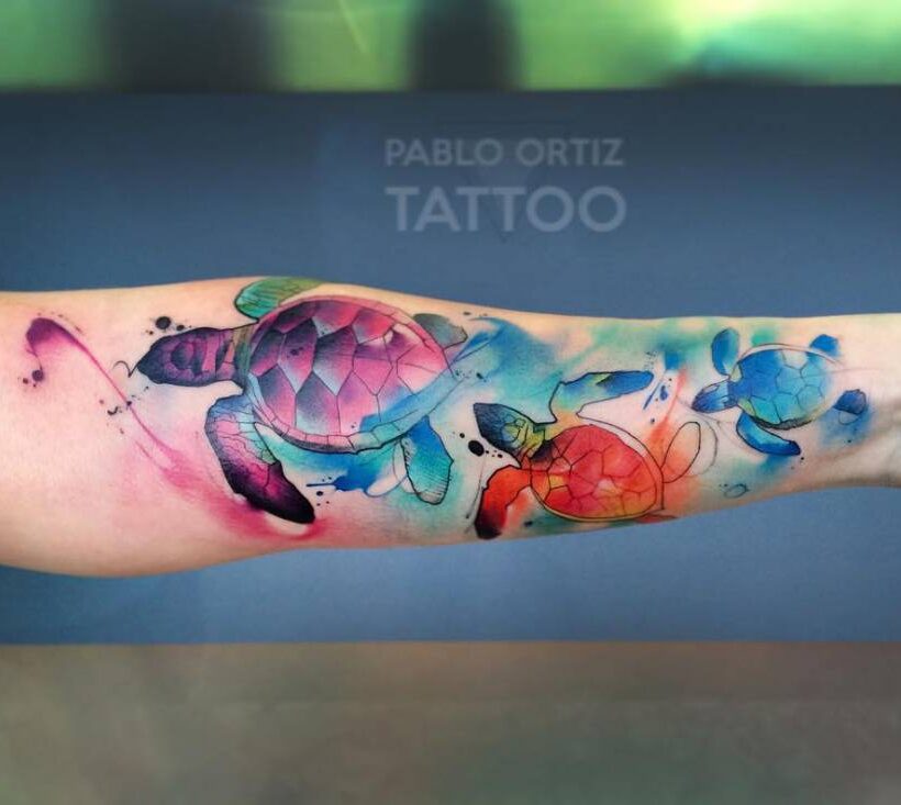 Watercolor style turtle tattoo on the forearm