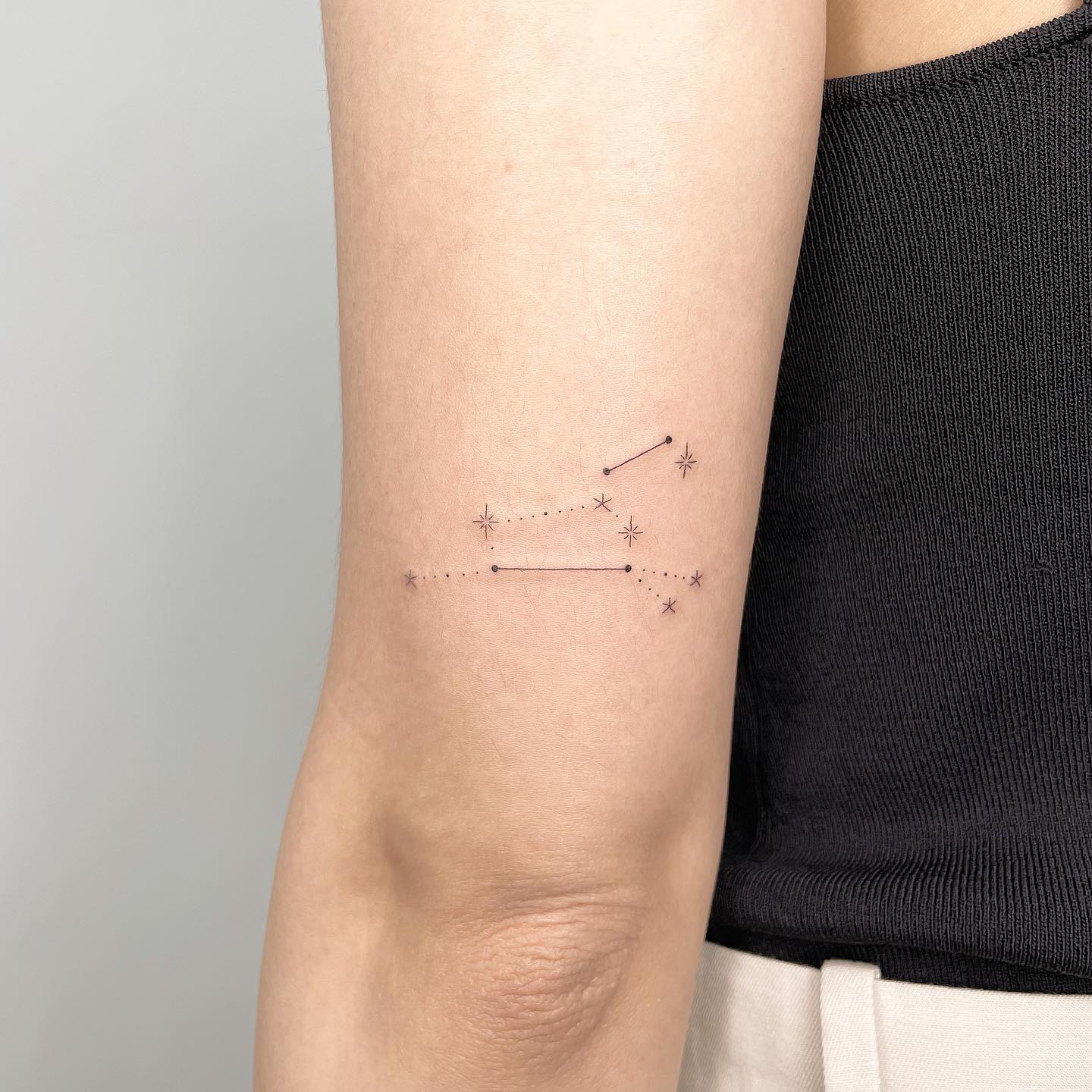 Minimalistic style Leo constellation tattoo located on the tricep