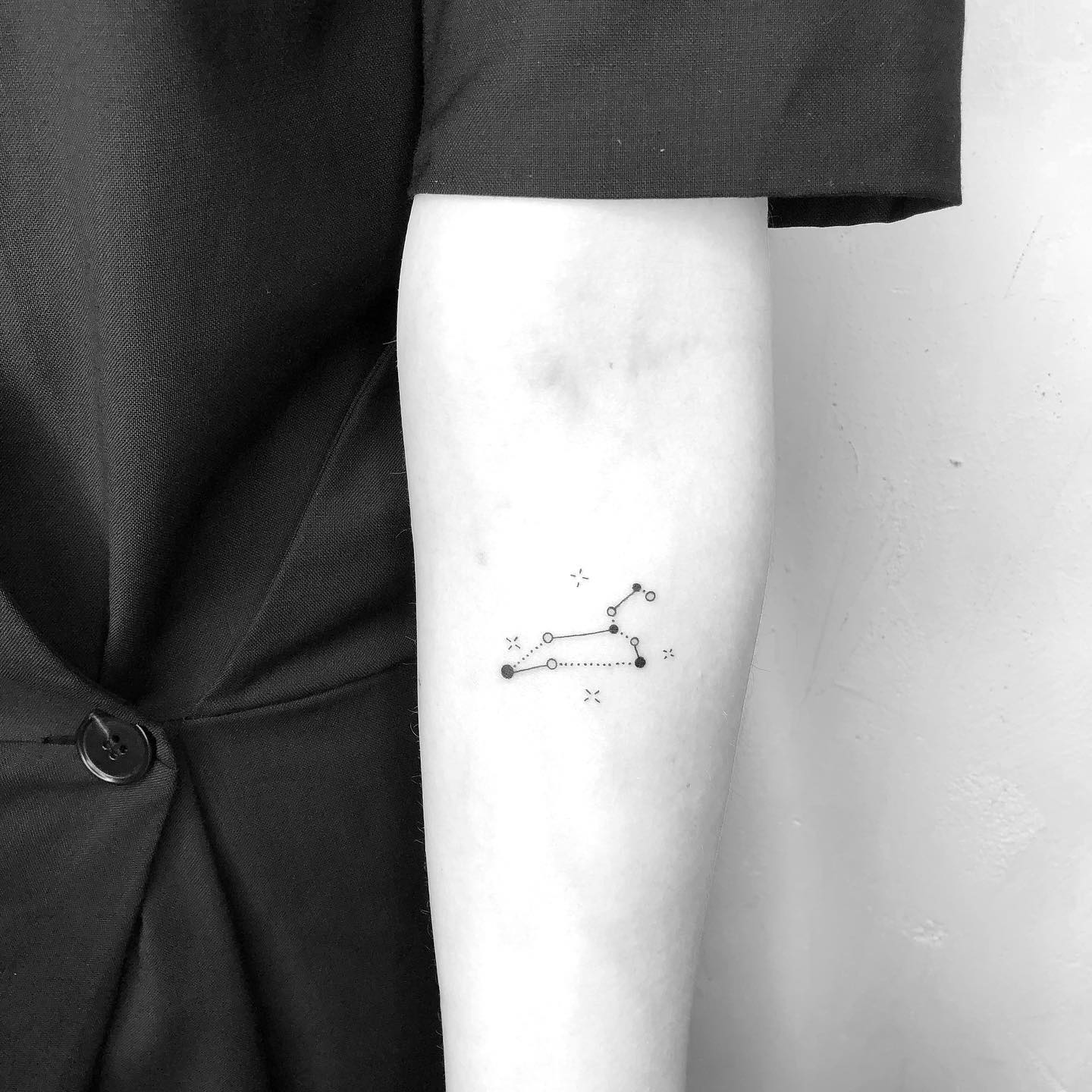 Minimalistic style Leo constellation tattoo on the inner forearm