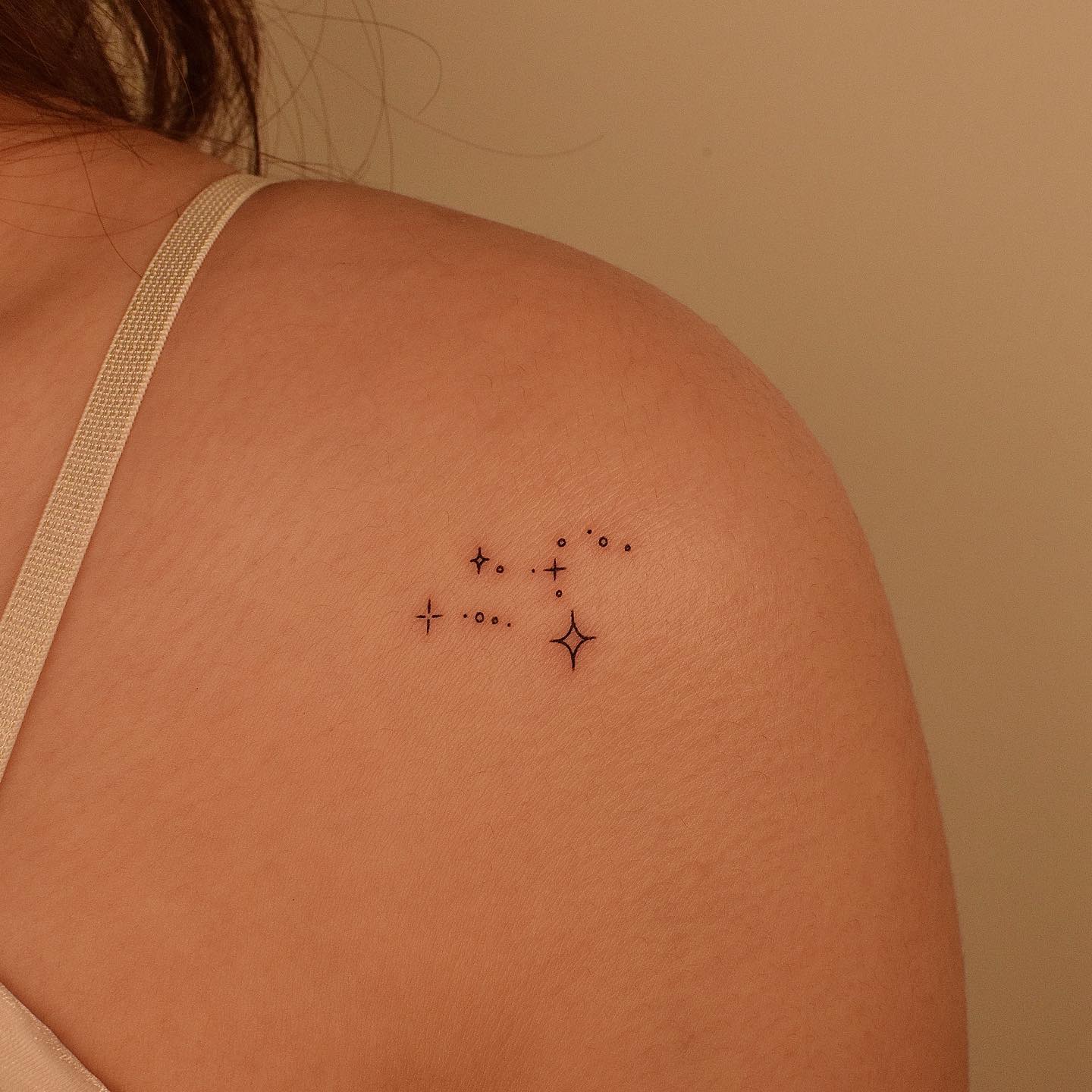 Minimalistic style Leo constellation tattoo located on the shoulder