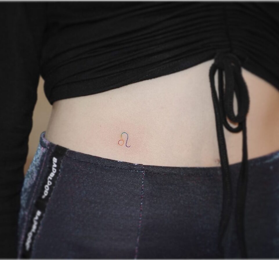 Fine line rainbow colored Leo symbol tattoo on the waist