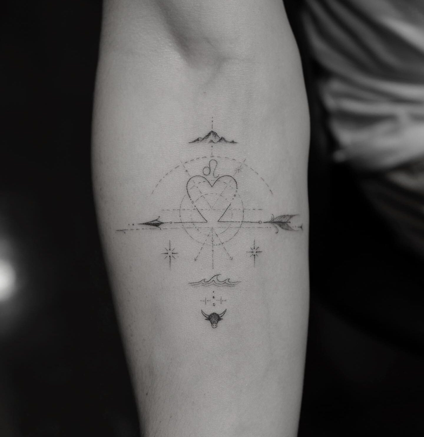 Personal compass and Leo symbol tattoo on the inner forearm