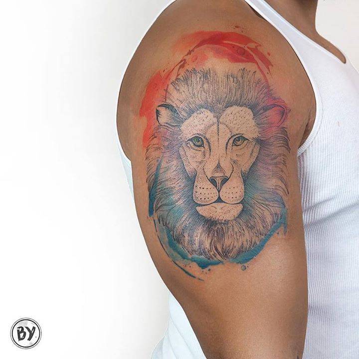 Watercolor style lion head tattoo on the right shoulder