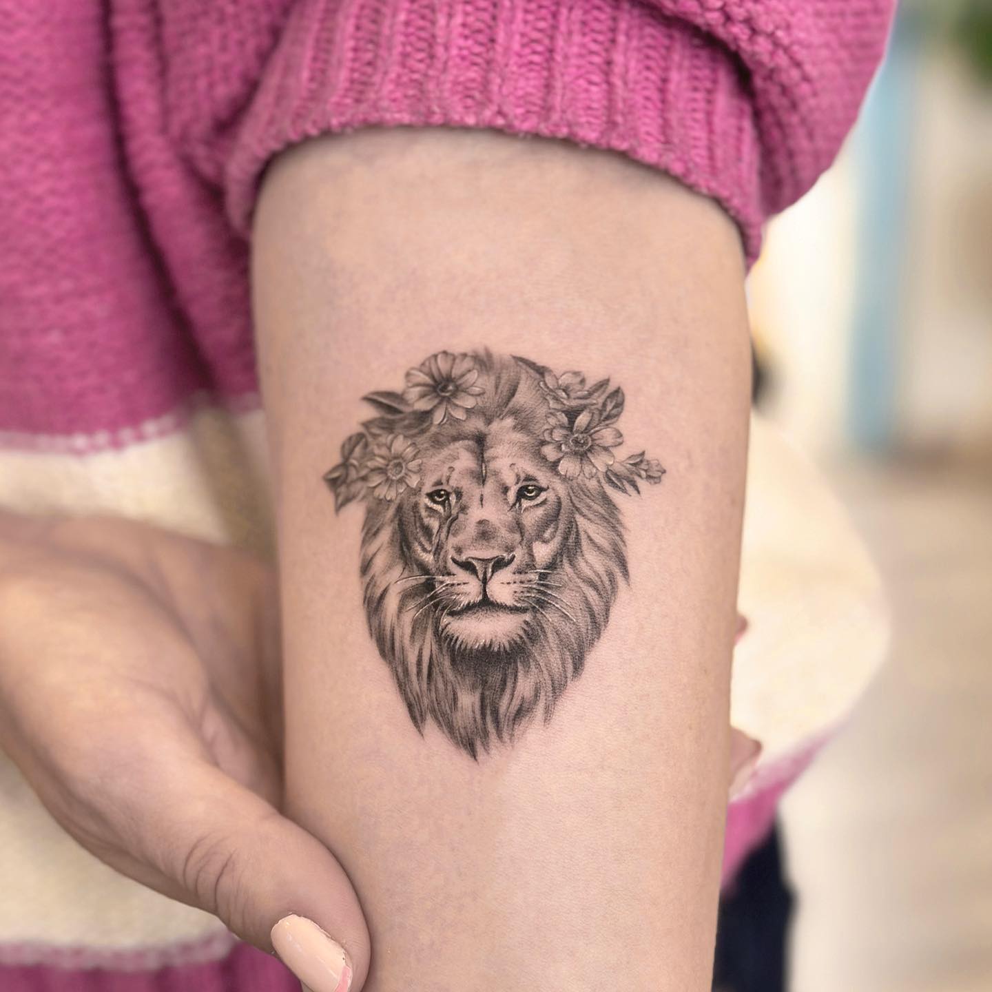 Micro-realistic lion portrait tattoo on the inner forearm