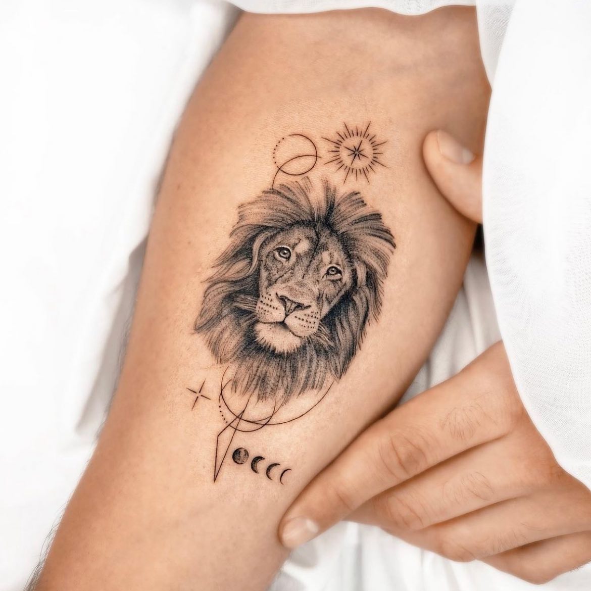 Micro-realistic lion portrait tattoo on the inner forearm