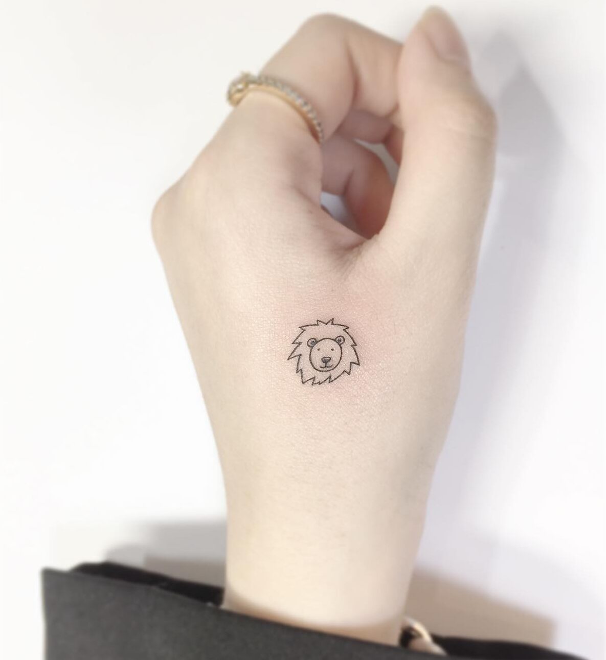 Little lion portrait tattoo on the hand, minimalistic style