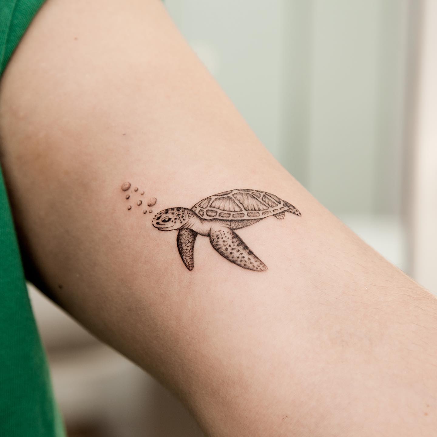 Micro-realistic turtle tattoo on the inner arm