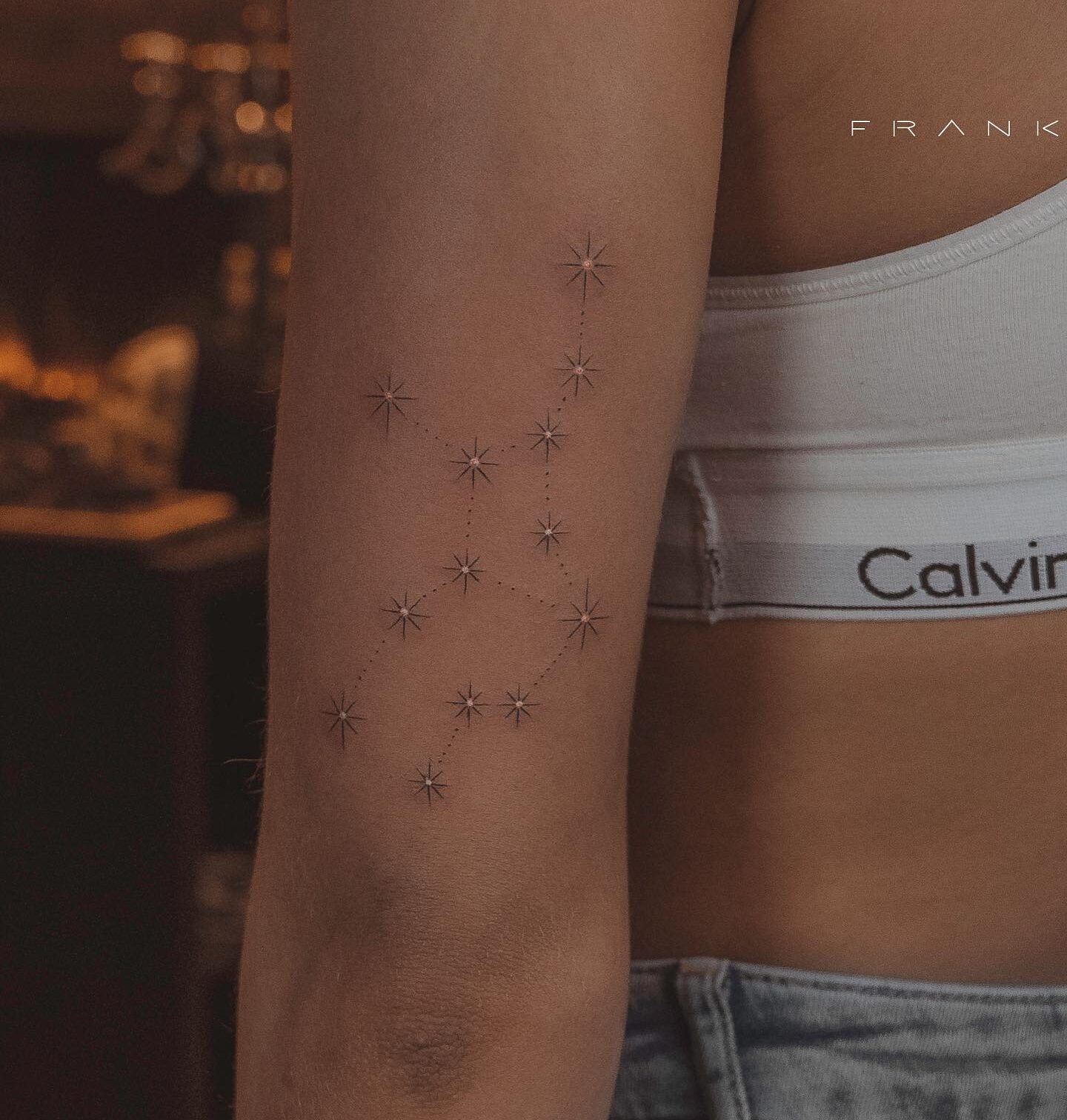 Fine line Virgo constellation tattoo on the tricep