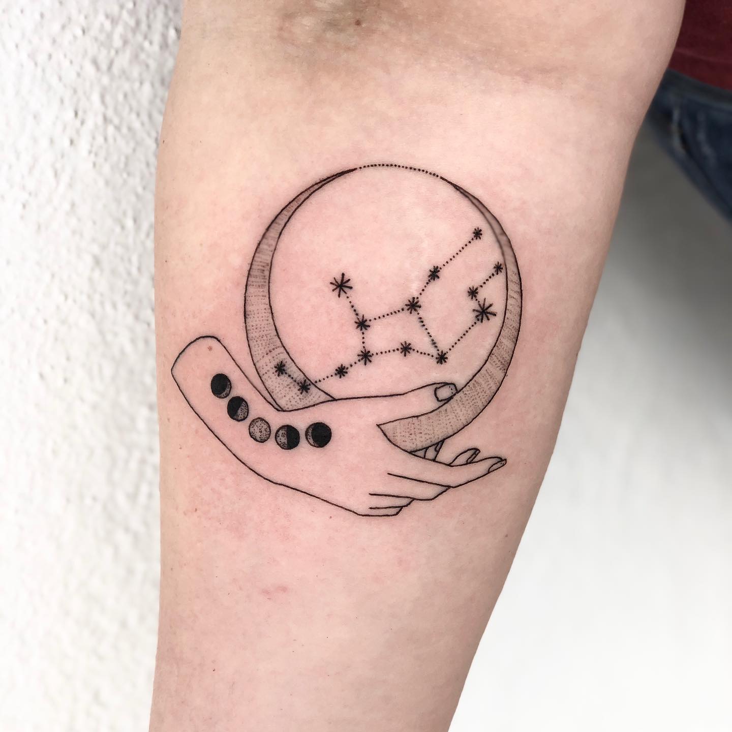 Moon phases and Virgo constellation tattoo on the inner forearm