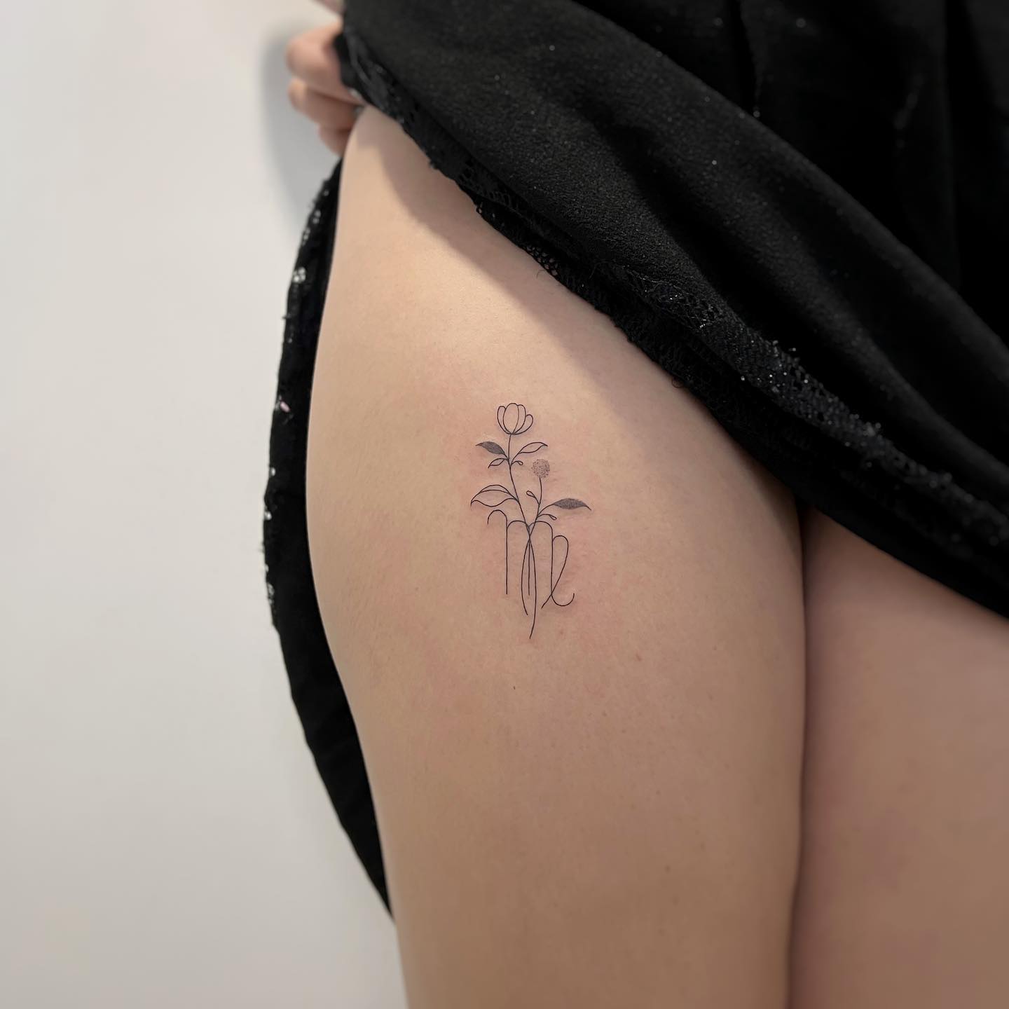 Virgo zodiac sign and flower tattoo on the thigh