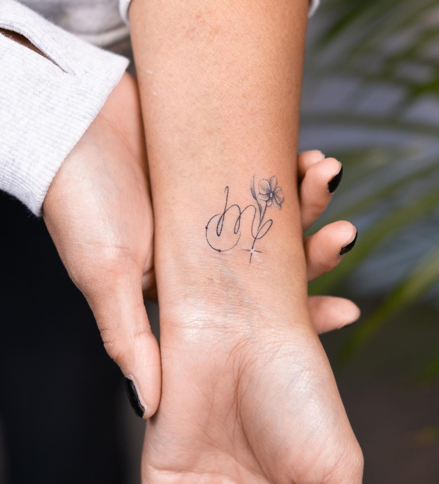 Virgo zodiac symbol and flower tattoo on the wrist
