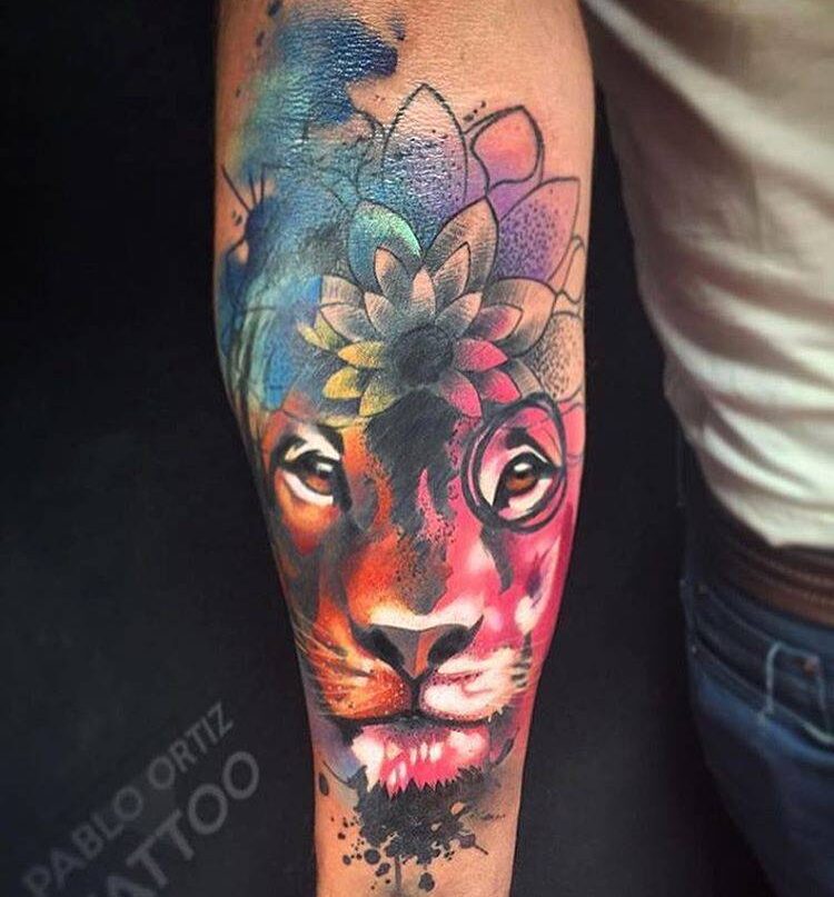 Watercolor style lion head tattoo on the inner forearm